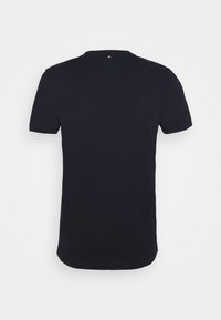 Granatowa koszulka z bawełny, z krótkimi rękawami i okrągłym dekoltem. Metka widoczna w okolicy tylnej szyi. Gładka faktura.