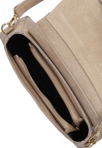 Beige handtas van glad leer en getextureerd suede, met zwarte voering en ritsen in goudkleur. Twee ritscompartimenten zichtbaar van binnen.