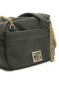 Sac en nylon vert foncé avec une surface texturée, doté d'une chaîne en doré et d'une plaque en métal rectangulaire.
