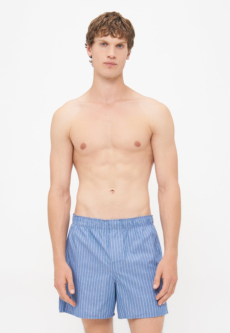 Pantaloni corti a righe blu chiaro realizzati in tessuto di cotone. Caratterizzati da una vita elasticizzata e una vestibilità morbida con tasche laterali.