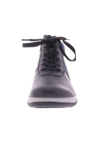 Zwarte en marineblauwe veterschoen met een bovenwerk van gestructureerd leer, lichte rubberen zool en ronde neus. Beschikt over zes veterogen en platte zwarte veters.