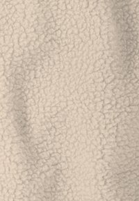 Zachte beige fleece stof met een zachte, gestructureerde oppervlak, met verhoogde vezels en een gelijkmatige uitstraling overal.