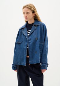 Džínová bunda, středně modrá, oversized střih. Má výstřih s klopami, dvojité knoflíky a ohrnuté manžety. Texturovaná tkanina, neformální design.
