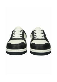 Čierno-biele tenisky s textúrovaným čiernym zvrškom, hladkým bielym koženým špikom a bielymi šnúrkami, s čiernymi gumovými podrážkami.