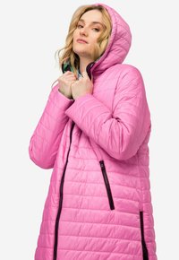 Abrigo de invierno acolchado rosa con capucha, que presenta una textura acolchada, cremalleras delanteras y bolsillos laterales. Tejido suave con un acabado brillante.