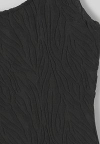 Tissu noir texturé présentant un motif ondulé en relief sur l'ensemble, avec un bord lisse d'un côté et des bords irréguliers de l'autre.