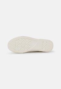 Sko såle i off-white gummi med en teksturert overflate, som har geometriske mønstre og sirkelformede grep for godt feste.