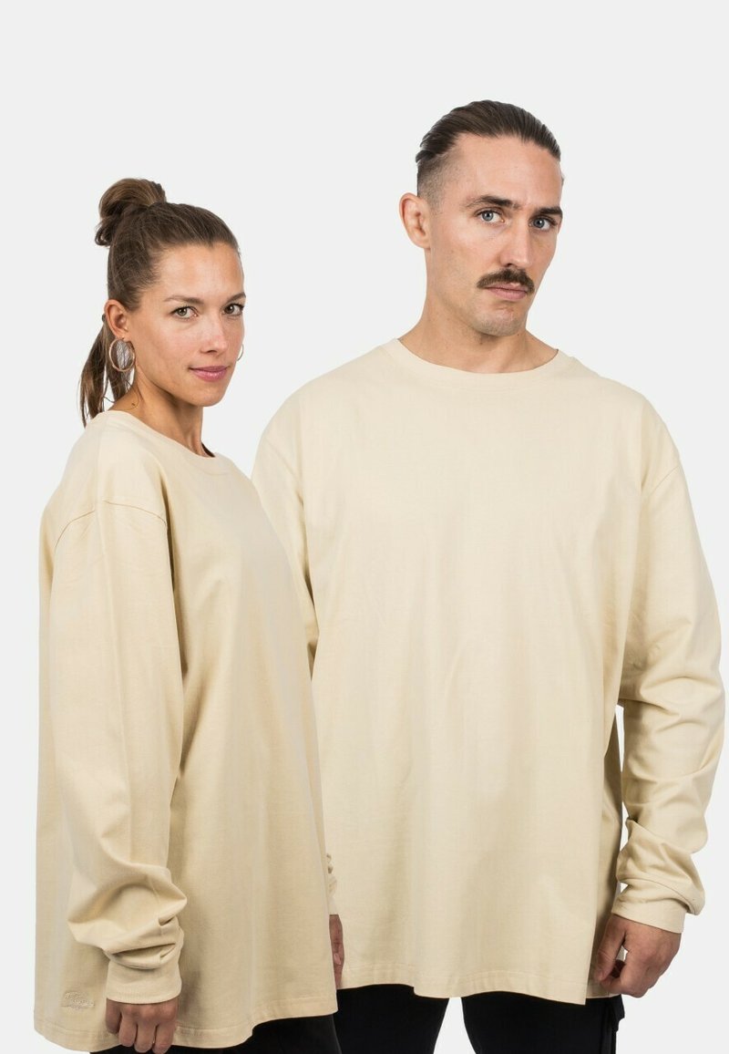 Beige Langarmhemden aus weicher Baumwolle mit einem lockeren Schnitt und Rundhalsausschnitt. Das Design umfasst Raglanärmel und Rippbündchen.