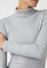 Jasnoszary sweter z golfem, o prążkowanym wzorze i dopasowanym kroju, z długimi rękawami, charakteryzujący się miękką fakturą i minimalnymi detalami.
