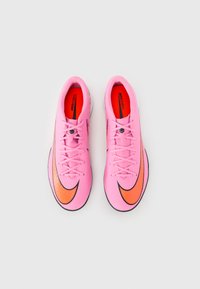 Baskets de sport roses avec une surface texturée, présentant des accents orange foncé et noirs, et des semelles noires. Comprennent des lacets et une doublure intérieure rouge.
