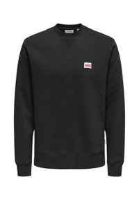 Svart sweatshirt med rund halsringning, ribbade mudd och fåll. Har en liten logotyp på bröstet. Tillverkad av mjukt, strukturerat tyg.