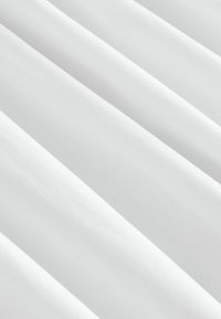Tissu blanc à la texture lisse, avec de douces plis et de légères rides, mettant en valeur un design propre et minimaliste.