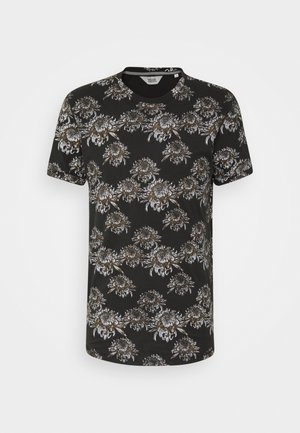 Czarny t-shirt z krótkim rękawem z powtarzającym się dużym wzorem kwiatowym w białych i brązowych odcieniach, z okrągłym dekoltem, prezentowany na jednolitym tle.