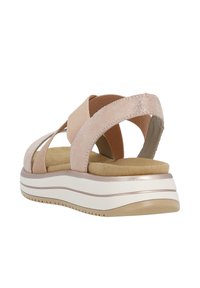 Light pink sandal with elastic straps, a suede texture, a cushioned footbed, and a white and tan platform sole featuring subtle grooves.