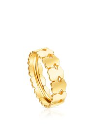 Anello in oro con un design a bordo ondulato e forme di trifoglio interconnesse, che presenta una finitura lucida e una texture liscia.