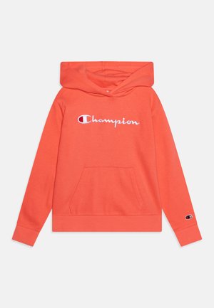 Sudadera color coral hecha de tela suave, con un bolsillo frontal, capucha con cordón y el logo "Champion" bordado en el pecho.