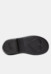 Suola di scarpa nera con un motivo testurizzato e un design a forma di cuore. Presenta il testo del marchio in rilievo su un lato. Materiale in gomma liscia.