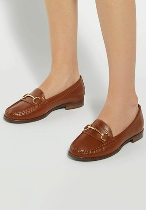 Brown leather loafers with a gold-tone accent, featuring a rounded toe and low heel, displaying stitched detailing along the upper.