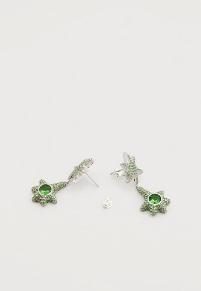 Πράσινα σκουλαρίκια σε σχήμα αστεριού με ένα κεντρικό πράσινο πολύτιμο λίθο, διακοσμημένα με μικρές πράσινες πέτρες, σε ασημένιο μέταλλο.