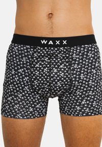 Boxers noirs avec un motif répété de pandas blancs, comportant une ceinture élastique noire avec "WAXX" imprimé en blanc.