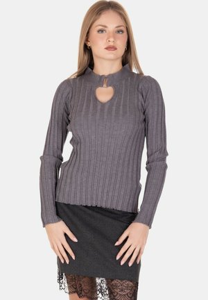 Maglione grigio a coste a maniche lunghe con un neckline a chiave, caratterizzato da un design aderente e un tessuto testurizzato, abbinato a una gonna a tubino nera.