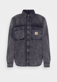 Černá vypraná denimová košile s dlouhým rukávem, dvěma předními kapsami na hrudi, zapínacími límci a nášivkou loga Carhartt na pravé kapse.