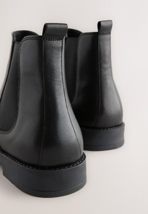 Stivaletti Chelsea neri in pelle con pannelli elastici laterali, punta arrotondata e suole in gomma durevoli. Dotati di linguette per una facile calzata.