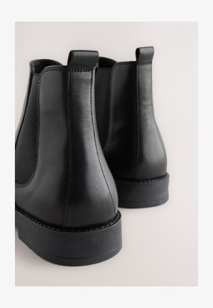 Stivaletti Chelsea neri in pelle con pannelli elastici laterali, punta arrotondata e suole in gomma durevoli. Dotati di linguette per una facile calzata.