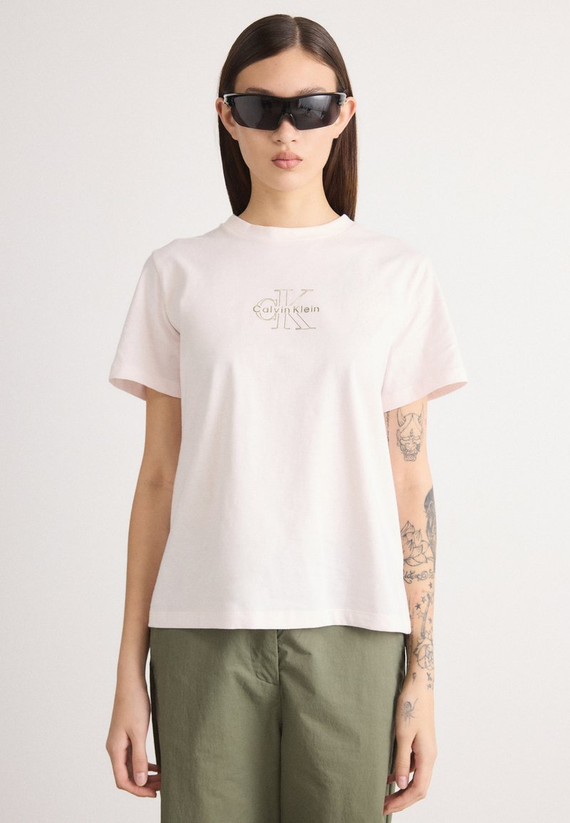 Ροζ βαμβακερό μπλουζάκι με κοντά μανίκια και στρογγυλή λαιμόκοψη. Διαθέτει έντονο μπεζ λογότυπο Calvin Klein στο στήθος.