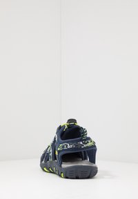 Námořnická outdoorová sandal s prodyšným textilním svrškem, jasně zelenými akcenty, nastavitelným popruhem, texturovanou podrážkou a otevřeným designem paty.