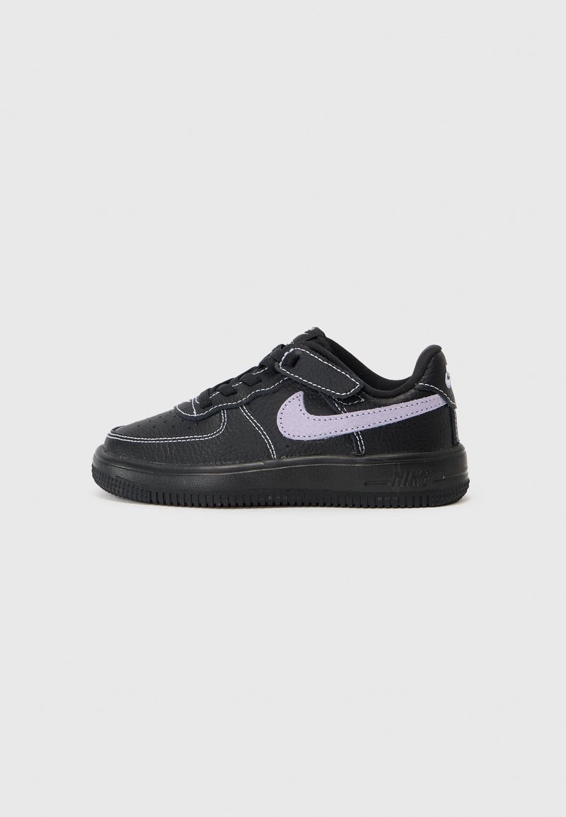Black sneaker with purple accents, textured leather upper, white stitching, lace-up design, and a rubber sole with tread pattern.