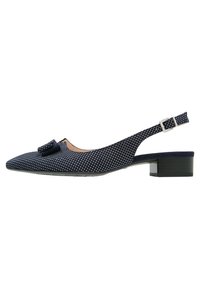 Zapato slingback de lunares azul marino con un bajo tacón cuadrado. Presenta un lazo decorativo y una hebilla plateada en la correa del tobillo. Material de ante.