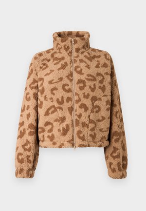 Viltota kažokāda apgriezta jaka tan krāsā ar brūniem leoparda plankumiem, augstu apkakli un priekšējo rāvējslēdzēju, ar mīkstu tekstūru un elastīgām aprocēm.