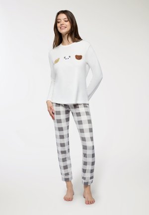 Top bianco a maniche lunghe con tre toppe di animali. Pantaloni del pigiama a scacchi grigi e bianchi. Tessuto morbido, vestibilità comoda. Nessun hardware visibile.