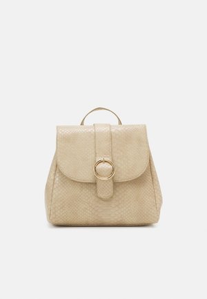 Beżowy plecak z ekoskóry z zaokrągloną klapką, fakturowanym wzorem wężowej skóry, okrągłym zapięciem z pozłacanym okuciem oraz górnym uchwytem.