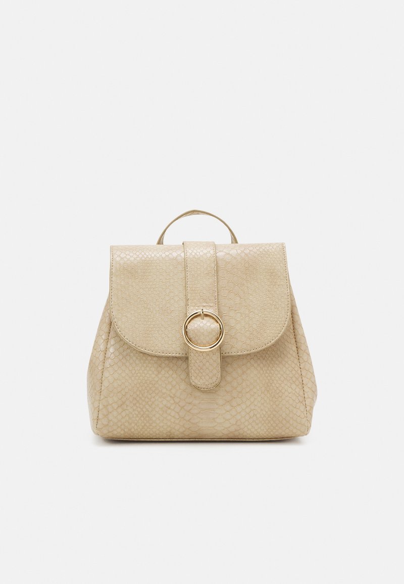 Mochila de piel sintética beige con solapa redondeada, patrón texturizado de serpiente, cierre circular de herrajes dorados y asa superior.