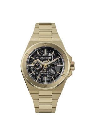 Montre automatique en acier inoxydable doré avec un cadran squeletté noir, des index horaires argentés et une lunette polie. Présente un bracelet à maillons.