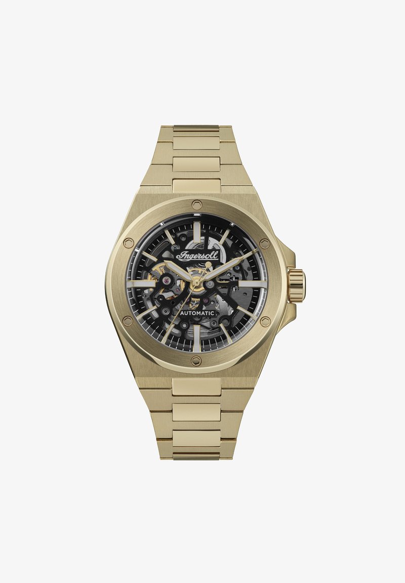 Montre automatique en acier inoxydable doré avec un cadran squeletté noir, des index horaires argentés et une lunette polie. Présente un bracelet à maillons.