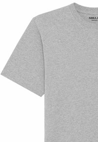 T-shirt en coton gris clair à manches courtes, col rond avec étiquette de marque "MIRA H" visible à l'intérieur du col.