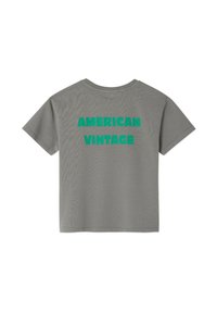 Hallhalli hallvast sinine t-särk, mille seljal on julge roheline tekst "AMERIKA VINTAAŽ". Lühikesed varrukad ja tavaline ümar kaelus. Puuvillane materjal.