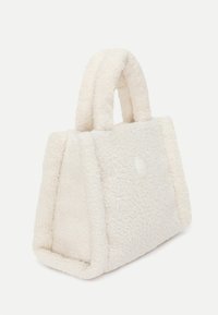 Fehér műszőrme kézitáska szilárd formában, két rövid fogantyúval és texturált, puha felülettel. Kerek logó részlet elöl.