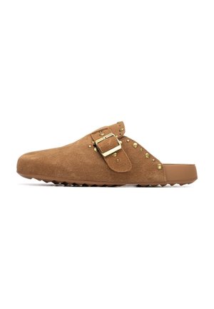 Zuecos marrones de ante sin cordones con hebilla dorada y detalles de tachuelas a lo largo del lateral, con una suela de goma texturizada para mayor agarre.