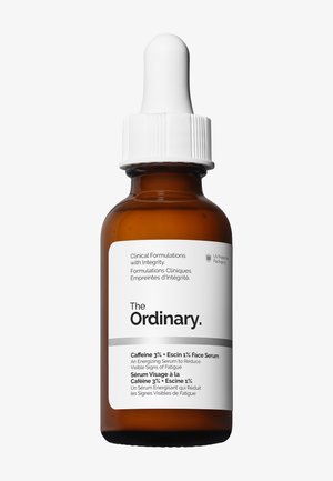 Bernsteinfarbene Tropfflasche mit weißem Etikett des The Ordinary Caffeine 3% + Escin 1% Gesichtsserums, das sichtbare Anzeichen von Müdigkeit reduziert.