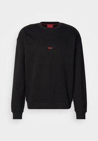 Sweat-shirt noir manches longues avec col rond, petit logo rouge "HUGO" centré sur la poitrine et poignets et ourlet côtelés.