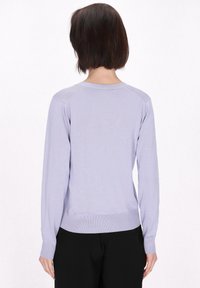 Svetlo vijolična dolga majica s long sleeves, z robe in manšetami, ki ima gladko teksturo in preprost okrogli izrez, prikazana s hrbtne strani.