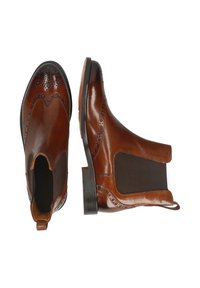 Bottines Chelsea en cuir marron avec une finition lisse, des détails en brogue, des panneaux latéraux élastiques et un faible talon empilé.