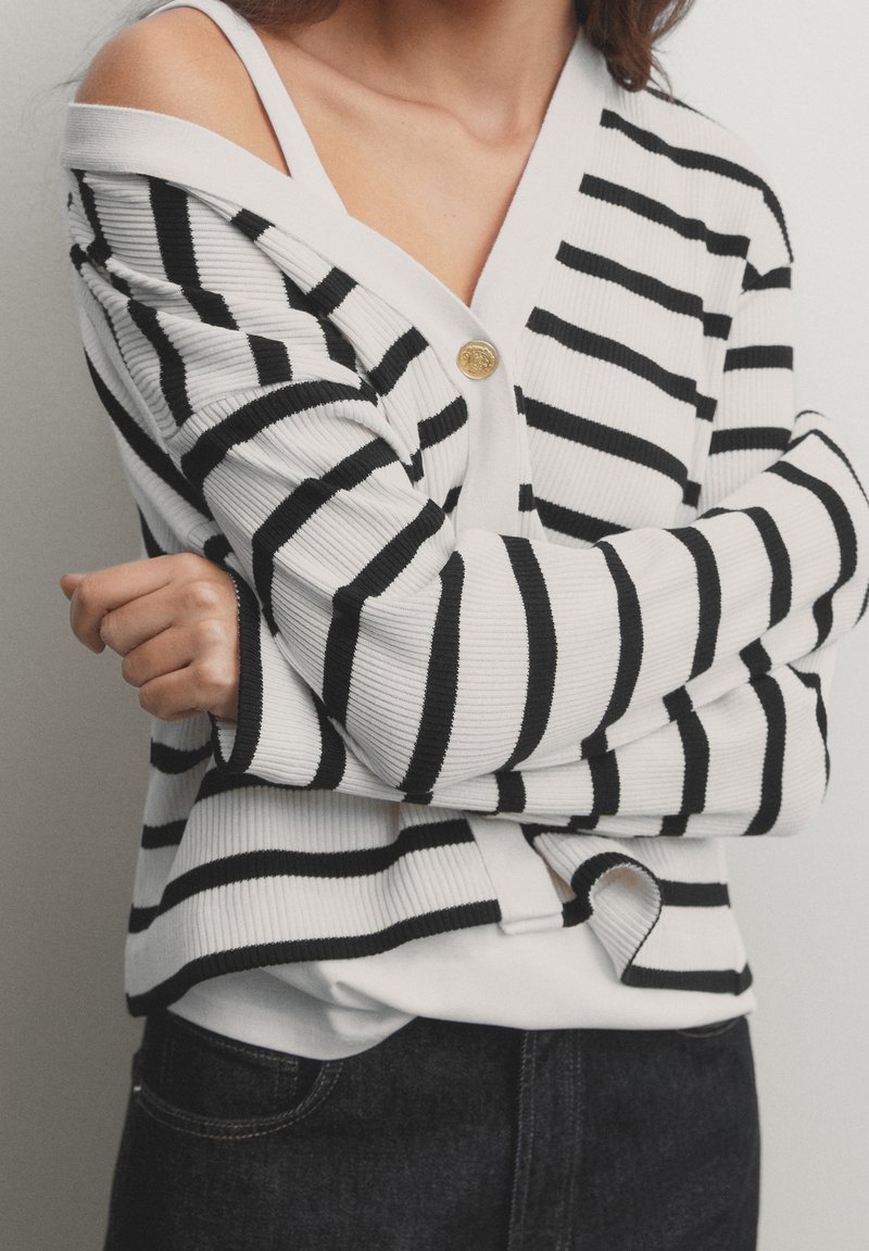 Black and white striped cardigan with a ribbed texture, featuring a front button closure and an open collar design.