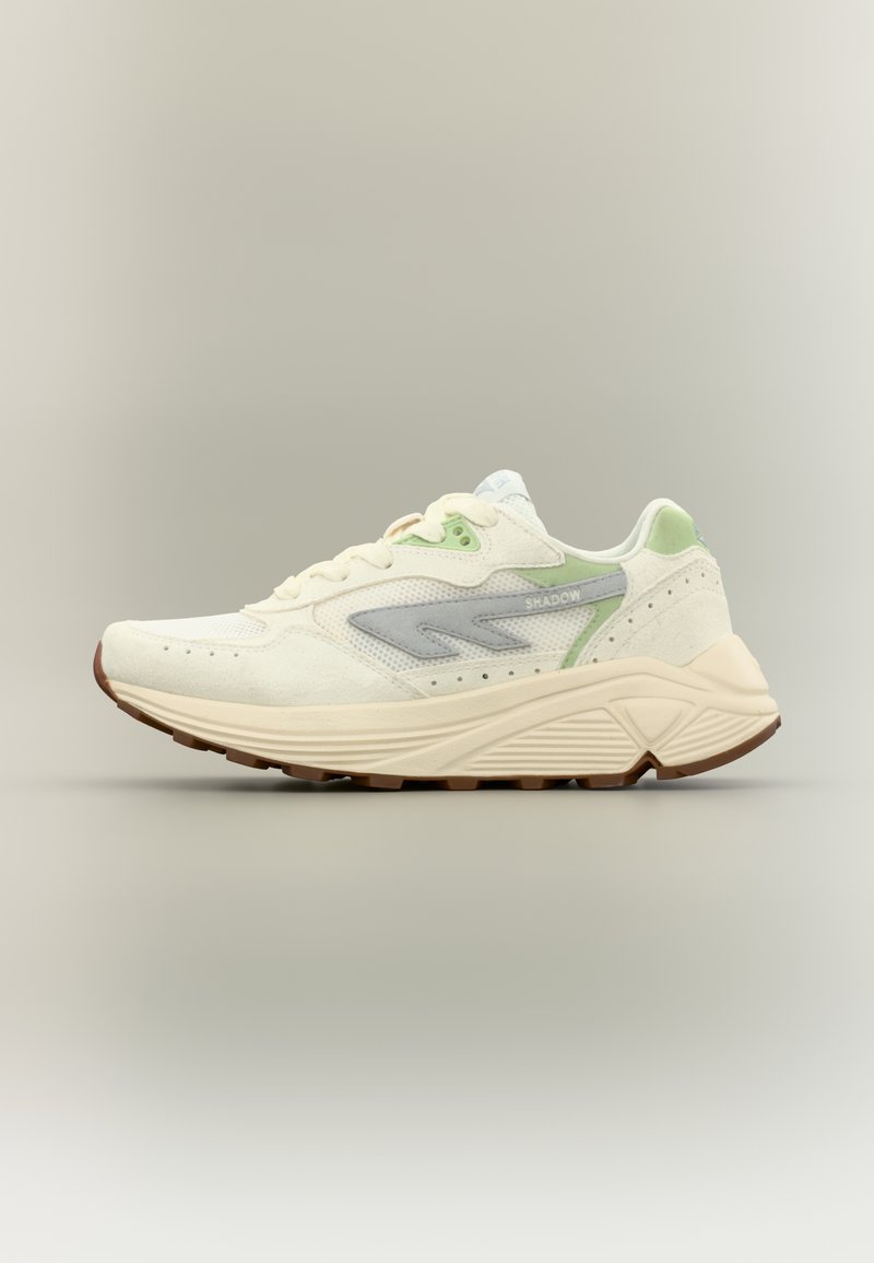 Lagana tenisica s gornjim dijelom od kremaste mrežaste tkanine, sivim i zelenim detaljima, teksturiranim jezikom, podstavljenim okovratnikom i robusnim smeđim gumenim potplatom.