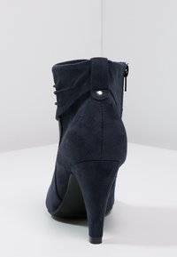 Granatowe zamszowe botki za kostkę na wysokim obcasie, z marszczonymi detalami i zamkiem błyskawicznym z boku, gładka tekstura.