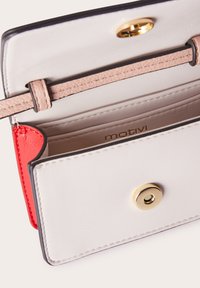Portafoglio rettangolare in pelle bianca con accenti rossi. Presenta una chiusura a scatto dorata e più slot per schede con una finitura liscia e testurizzata.